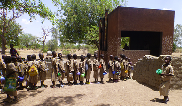 Primary school children lining up for lunch at the school kitchen.